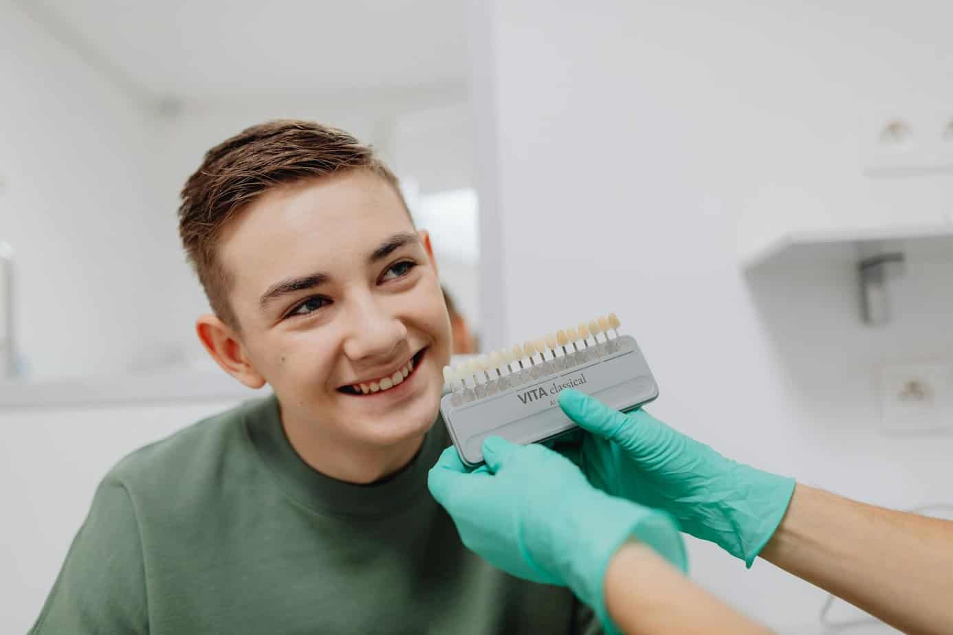 A young man is getting his teeth cleaned by a dentist, preparing for veneers.